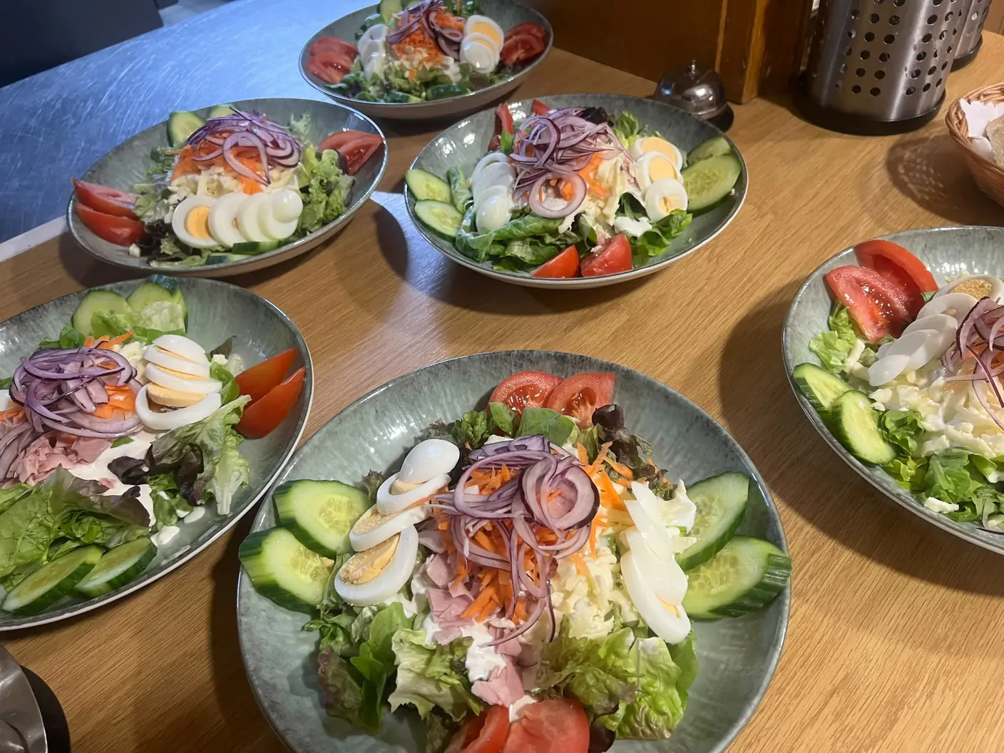 Mehrere gemischte Salate mit Ei, Gurken, Tomaten, roten Zwiebeln und frischem Blattsalat