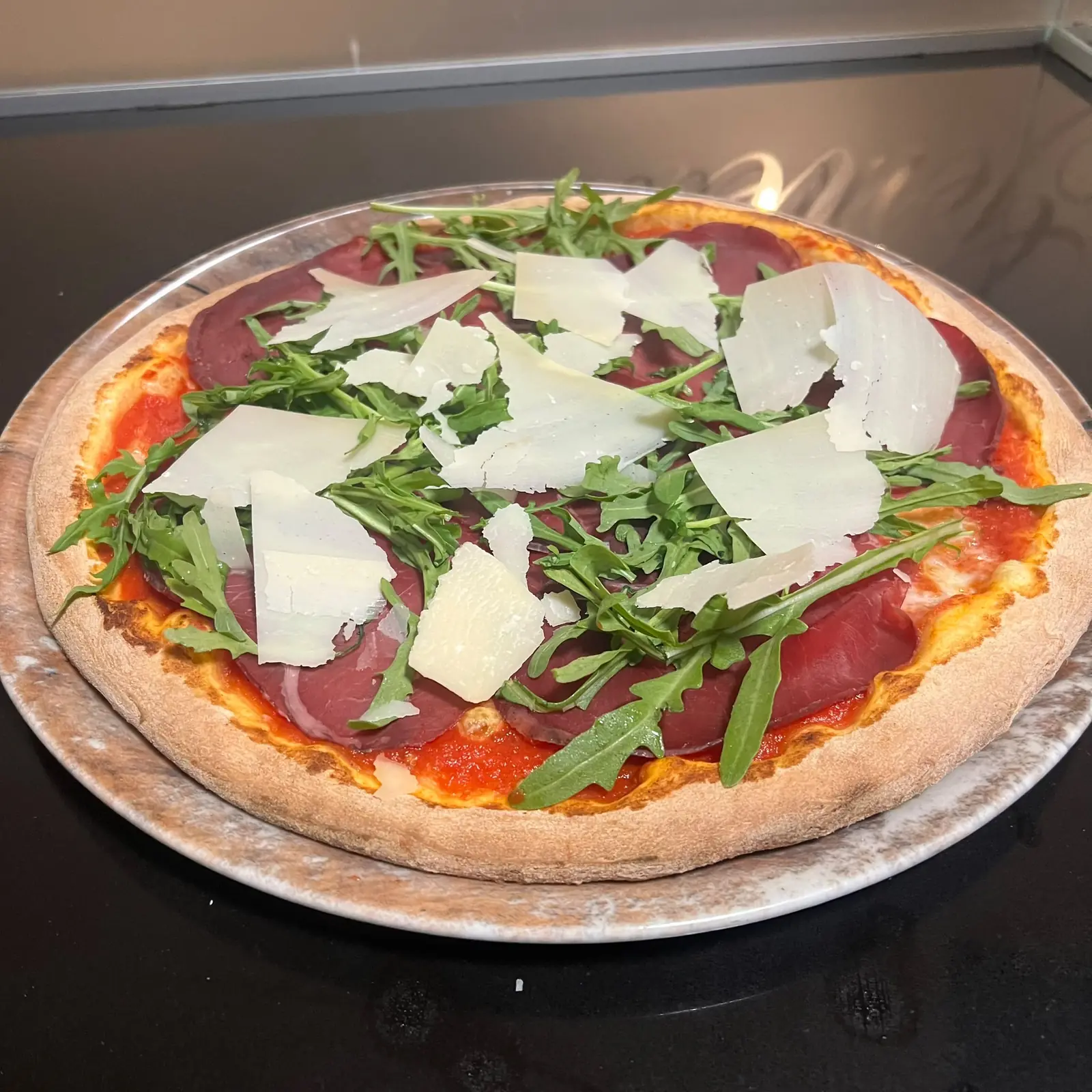 Pizza mit Bresaola, Rucola und Parmesanspänen